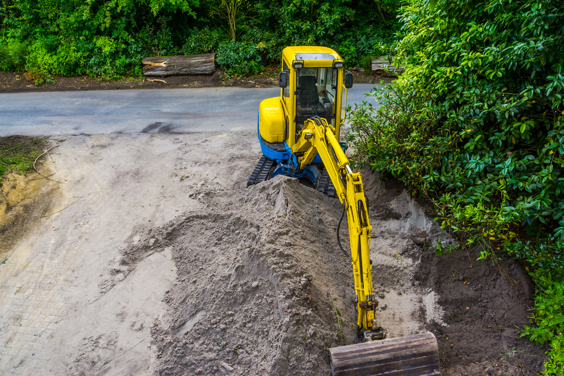 yellow excavator scraping the sand